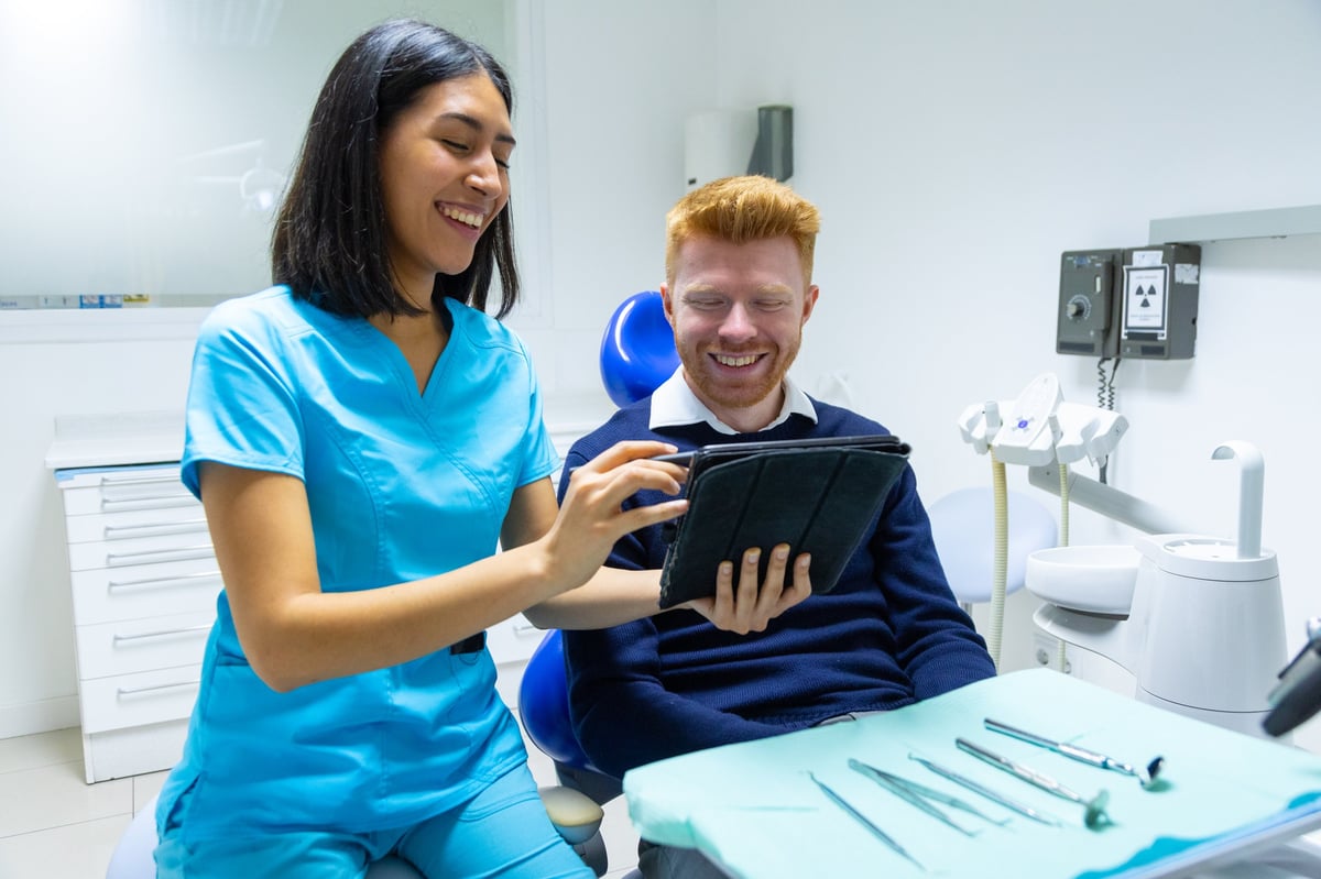 Dental professional explaining treatment options to a patient in a modern clinic